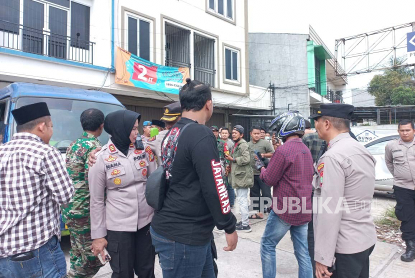 Polisi berjaga saat terjadi bentrok antarormas di kompleks ruko BFI Finance, Jalan Sultan Hasanudin Nomor 233 Ruko 2, Desa Tambun, Kabupaten Bekasi, Jumat (10/2/2023).