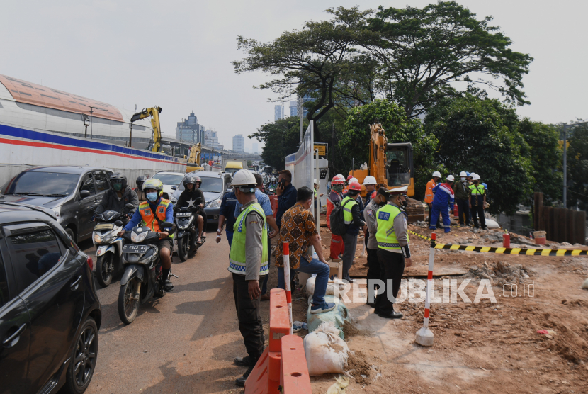 Petugas kepolisian meninjau lokasi kebocoran pipa gas di Jalan MT Haryono, Tebet, Jakarta, Rabu (20/7/2022). Pipa gas PGN mengalami kebocoran di lokasi pengerjaan proyek revitalisasi halte terintegrasi Transjakarta dan LRT. 