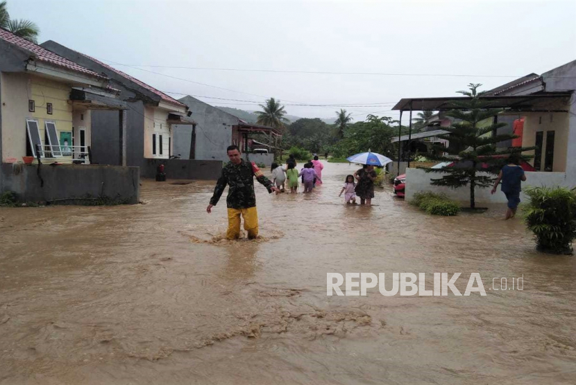 Warga menerobos banjir di Kolaka, Sulawesi Tenggara. Lebih dari 1.000 rumah terkena dampk banjir di Kolaka.