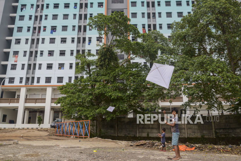 Anak-anak bermain layangan dengan latar belakang gedung Rusunawa Cipinang Besar Utara, Jakarta. Pemprov DKI mengaku tidak bisa memutihkan biaya sewa penghuni rusunawa yang nunggak.