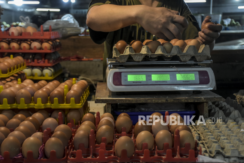 Pedagang menata telur ayam di lapaknya di Pasar. ilustrasi