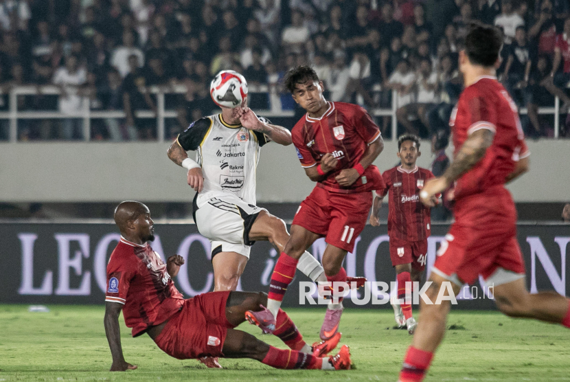 Pesepak bola Persija Jakarta Fabio Da Silva Calonego (kedua kiri) berebut bola dengan dua pesepak bola Persis Solo Moh. Sidik Saimima (kanan) dan Gervane Zjandric Adonnis Kastaneer (bawah) pada pertandingan BRI Super League di Stadion Manahan, Solo, Jawa Tengah, Sabtu (16/8/2025). Persija Jakarta menang atas Persis Solo dengan skor 3-0. 