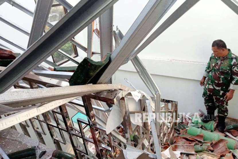 Petugas melihat kondisi bangunan Gedung KUA Kecamatan Cipatujah, Kabupaten Tasikmalaya, Jawa Barat, yang dilaporkan atapnya ambruk akibat gempa, Kamis (28/12/2023). 
