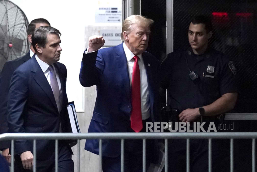 Mantan Presiden Donald Trump mengacungkan tinjunya saat berjalan menuju ruang sidang usai jeda persidangannya di pengadilan pidana Manhattan di New York, pada Jumat, (10/5/2024).