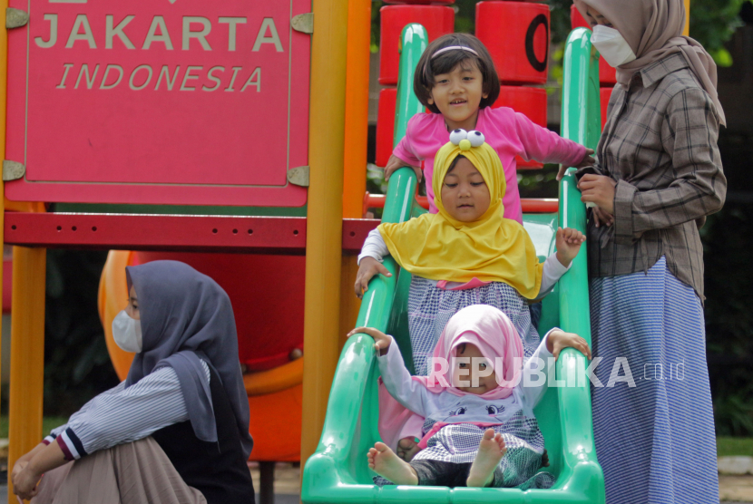 Orang tua mendampingi anaknya bermain di RPTRA Garuda, Cipayung, Jakarta Timur,  Ahad (9/10/2022). Taman tersebut menyediakan  fasilitas taman bermain untuk mendukung perkembangan anak dan memberikan kenyamanan agar bisa berinteraksi dengan seluruh warga dari berbagai kalangan. 