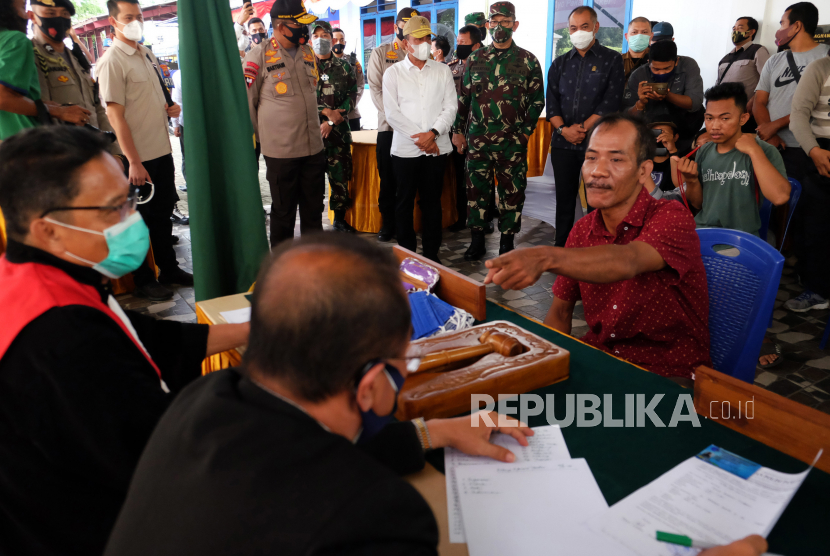 Seorang warga pelanggar protokol kesehatan mengikuti sidang Operasi Yustisi disaksikan Gubernur Sumatera Utara Edy Rahmayadi (kelima kiri) Pangdam I/Bukit Barisan Mayjen TNI Irwansyah (keenam kiri) dan Kapolda Sumut Irjen Pol Martuani Sormin (keempat kiri) di Medan, Sumatera Utara, Selasa (15/9/2020). Sidang Operasi Yustisi dalam rangka peningkatan disiplin dan penegakan hukum protokol kesehatan dalam upaya pencegahan penyebaran COVID-19 tersebut, memberikan sanksi kepada pelanggar yakni dengan menahan KTP selama tiga hari dan menyapu jalan bagi warga yang tidak memiliki KTP.