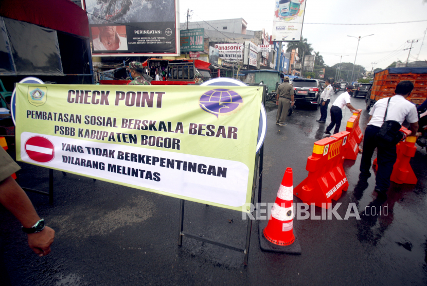 Petugas Dishub Kabupaten Bogor mempersiapkan spanduk dan rambu-rambu jalan jelang diberlakukan Pembatasan Sosial Berskala Besar (PSBB) di Jalan Raya Bogor, Cibinong, Bogor, Jawa Barat, Selasa (14/4/2020). Untuk mecegah meluasnya penyebaran virus Corona (COVID-19), Pemerintah Kabupaten Bogor mengajak seluruh lapisan masyarakat untuk menaati peraturan-peraturan di saat diberlakukanya PSBB di Kabupaten Bogor pada Rabu (15/4/2020)