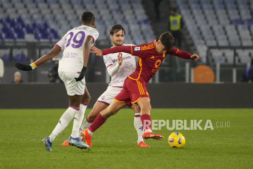 Paulo Dybala dari Roma (kanan) berebut bola dengan Christian Kouame dari Fiorentina (kiri) dan Luca Ranieri dari Fiorentina saat pertandingan sepak bola Seri A antara Roma dan Fiorentina di stadion Olimpiade Roma, Senin (10/12/2023) dinihari WIB.