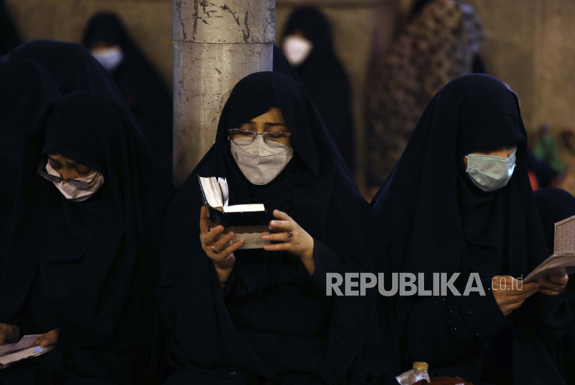  Para jamaah yang mengenakan masker pelindung wajah untuk membantu mencegah penyebaran virus corona, berdoa di Laylat al-Qadr, atau malam takdir, di bulan puasa Ramadhan, di tempat suci Saint Abdulazim di Shahr-e-Ray, selatan ibu kota Teheran, Iran, Senin, 3 Mei 2021.
