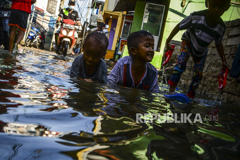 Anak-anak bermain air pasca-terjadinya banjir rob di kawasan Muara Angke, Jakarta.