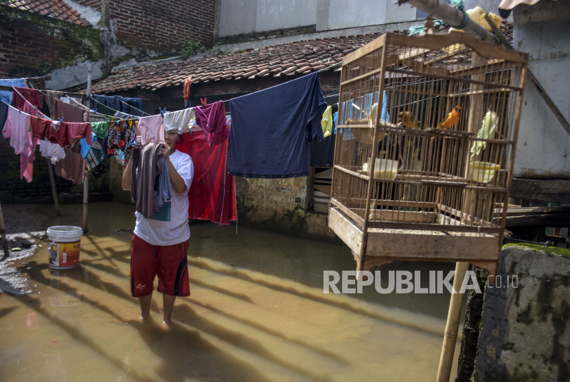 Warga menjemur pakaiannya saat banjir menggenangi Kampung Bojongasih, Kecamatan Dayeuhkolot, Kabupaten Bandung, Jumat (26/11). Saat musim hujan dan banjir, beberapa penyakit infeksi dapat mengusik kesehatan.