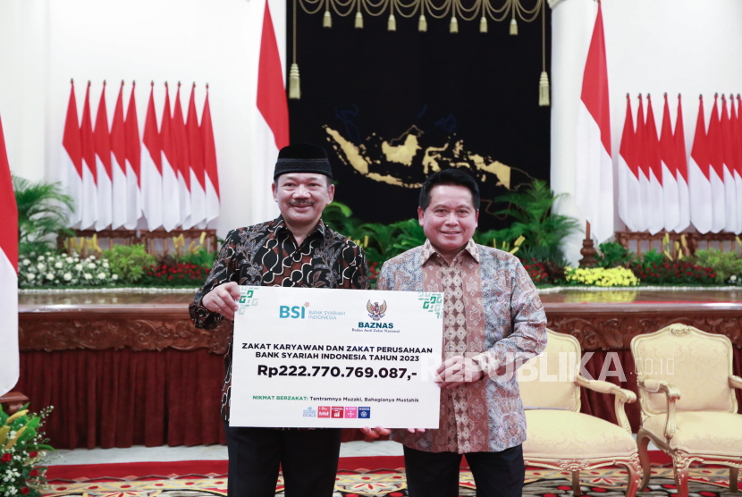 Direktur Utama PT Bank Syariah Indonesia Tbk Hery Gunardi (kanan) menyerahkan secara simbolis zakat perusahaan BSI kepada Ketua Baznas RI Noor Achmad di Istana Negara, Rabu (13/3/2024). 