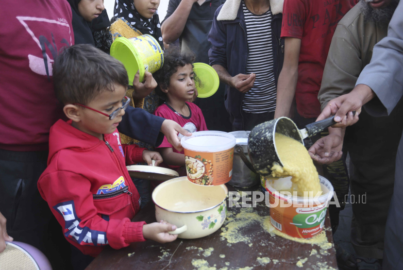 Anak-anak Gaza antre untuk mendapatkan makanan selama pengeboman Israel yang sedang berlangsung di Jalur Gaza di Rafah pada Senin, 13 November 2023.