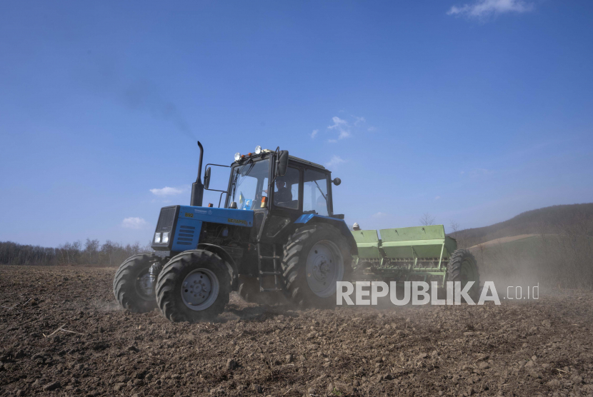 Pekerja membajak gandum di desa Husakiv, Ukraina barat. Sebanyak lima pabrik gandum di Gaza mulai kekurangan pasokan akibat invasi Rusia ke Ukraina