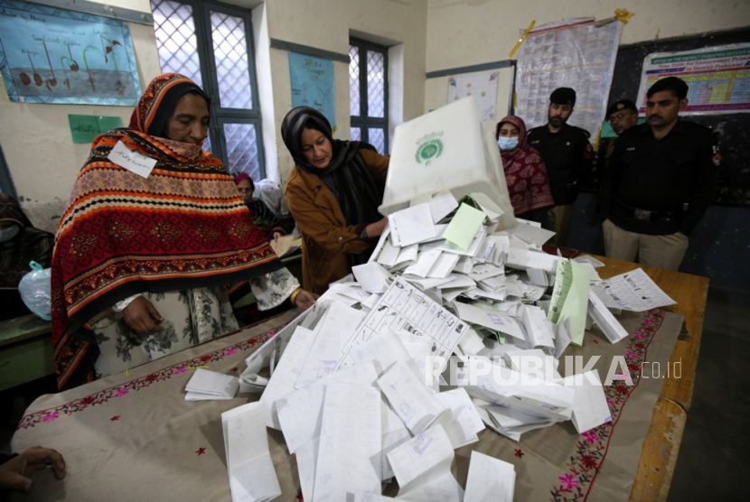 Petugas pemungutan suara menghitung surat suara di TPS saat pemilihan umum (pemilu) berakhir, di Peshawar, Pakistan, 8 Februari 2024. 