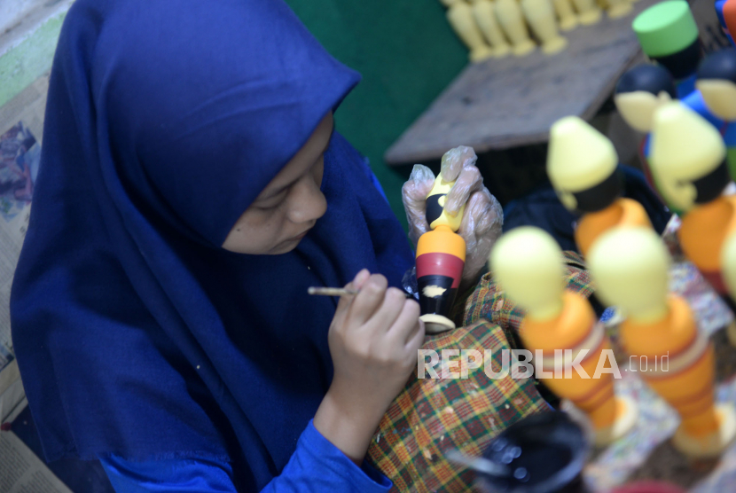 Perajin mewarnai boneka kayu di Barokah Craft, Pakem, Sleman, Yogyakarta.
