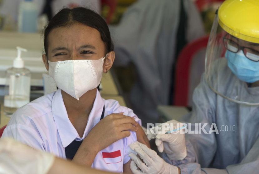 Reaksi seorang siswa SMP saat menerima suntikan vaksin Sinovac untuk COVID-19 selama kampanye vaksinasi di sebuah sekolah di Denpasar, Bali, Senin (5/7).