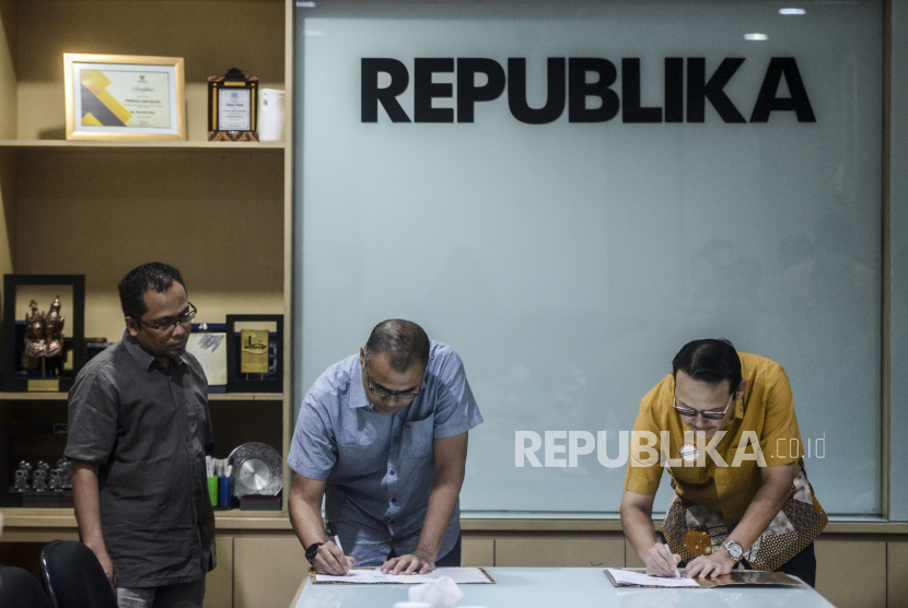 Pemimpin Redaksi Republika Irfan Junaidi bersama Wakil Pemimpin Redaksi Republika Nur Hasan Murtiaji dan Direktur Utama BPJS Kesehatan Fachmi Idris saat penandatanganan MoU di Kantor Republika, Jakarta, Jumat (20/3). Republika bersama BPJS Kesehatan dan Ikatan Dokter Indonesia (IDI) bekerjasama menyelenggarakan penggalangan dana untuk pengadaan APD tenaga medis yang melayani penderita Corona atau Covid-19. Putra M. Akbar/Republika(Putra M. Akbar/Republika)