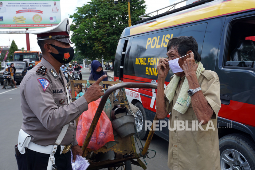 Petugas Satuan Lalu Lintas Polres Sorong Kota (kiri) mengingatkan pentingnya penggunaan masker kepada warga di Kota Sorong, Papua Barat, Kamis (10/9/2020).