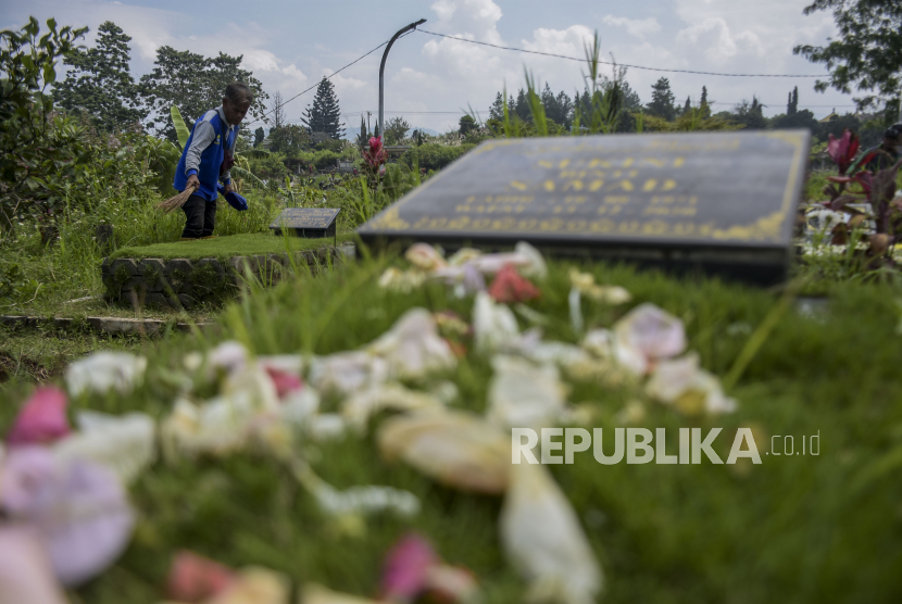 Petugas membersihkan makam di Tempat Pemakaman Umum (TPU) Cikadut, Mandalajati, Kota Bandung, Jawa Barat, Senin (20/3/2023). Menjelang bulan suci Ramadhan, TPU Covid-19 Cikadut ramai dikunjungi peziarah yang datang untuk mendoakan keluarga serta kerabat yang telah wafat.