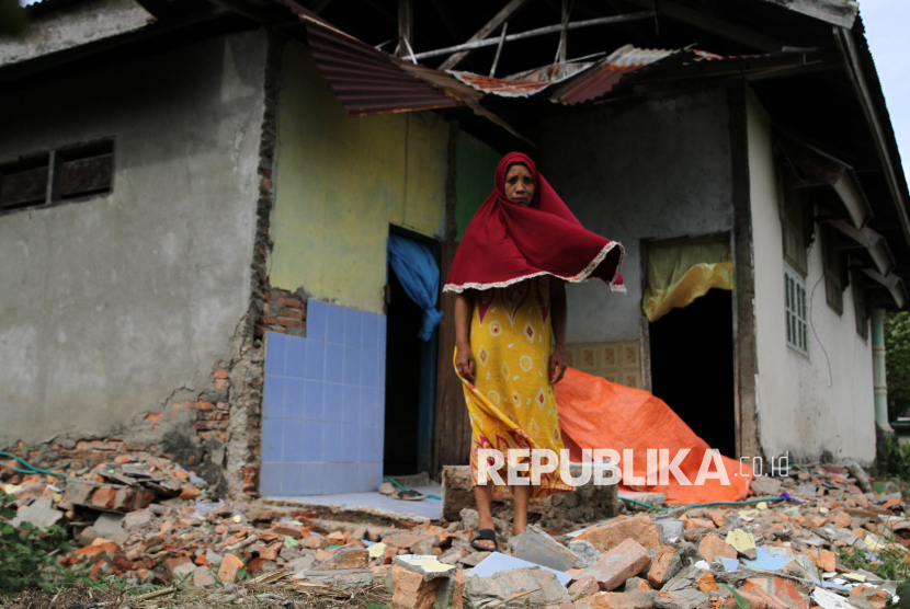 Seorang warga berdiri di atas puing dinding rumahnya yang roboh akibat gempa bumi di Kecamatan Mowewe, Kolaka Timur, Sulawesi Tenggara, Kamis (30/1/2025). BPBD setempat mencatat jumlah rumah rusak berat akibat gempa bumi sebanyak tiga unit dan rusak ringan 49 unit, serta bangunan gedung pelayanan publik, kesehatan, rumah ibadah dan sekolah sebanyak 10 unit yang tersebar di Kecamatan Mowewe dan Kelurahan Lalolae. 