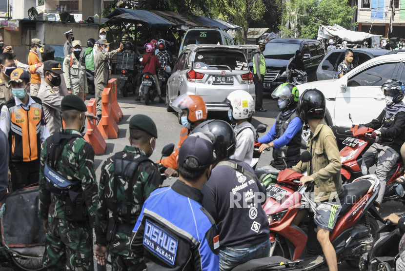 Petugas gabungan dari TNI, Polri, Dishub, dan Satpol PP memutarbalikkan kendaraan yang akan melintas di pos PPKM Darurat, Bekasi