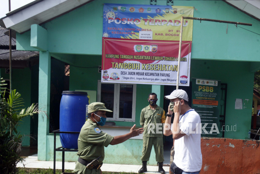 Satgas Covid-19 tingkat desa menghimbau warga untuk memakai masker di Posko Covid-19 sebelum memasuki Desa Jabon Mekar, Parung, Kabupaten Bogor, Jawa Barat, beberapa waktu lalu.