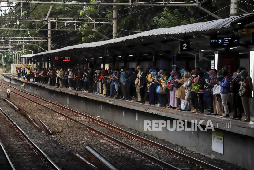 Sejumlah penumpang mengantre dengan menerapkan pembatasan jarak fisik saat akan menaiki KRL di Stasiun Sudirman, Jakarta, Senin (8/6). Lonjakan penumpang terjadi saat hari pertama dimulainya aktifitas perkantoran di Jakarta pada masa transisi pembatasan sosial berskala besar (PSBB)