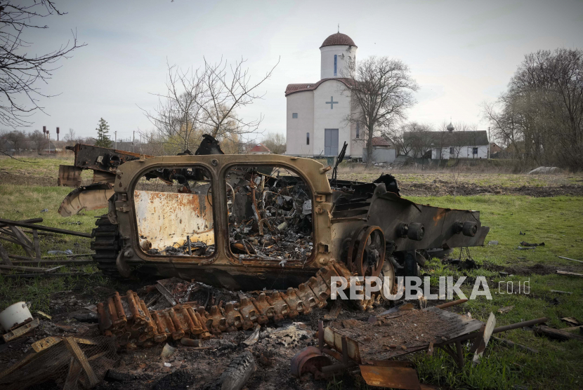 Fragmen kendaraan militer Rusia yang hancur berserakan dengan latar belakang gereja Ortodoks di desa Lypivka dekat Kyiv, Ukraina, pada 11 April 2022. 