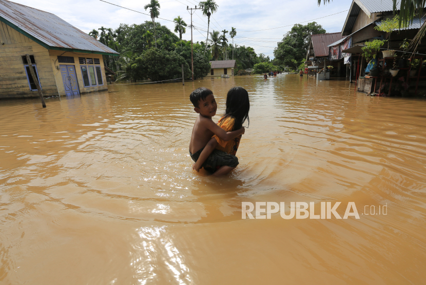 Anak-anak berjalan di depan rumahnya yang terendam banjir (ilustrasi)