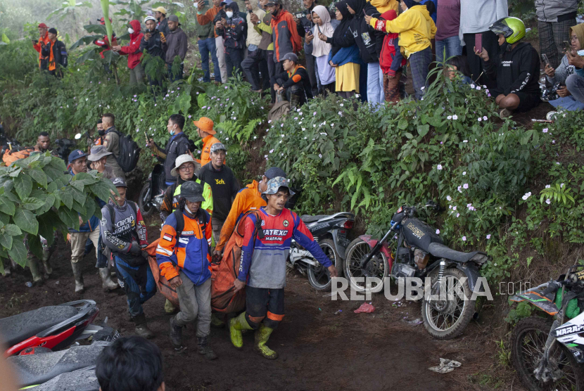 Rescuers carry the body of a victim of the eruption of Mount Marapi in Batu Palano, West Sumatra, Indonesia, Tuesday, Dec. 5, 2023. Rescuers searching the hazardous slopes of the volcano found more bodies of climbers who were caught by a surprise weekend eruption, raising the number of confirmed dead to nearly two dozens, officials said Tuesday.  