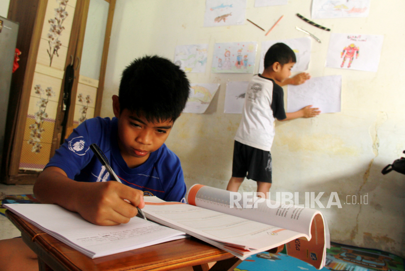 Dua anak belajar dengan bimbingan orang tuanya di rumahnya, ilustrasi.