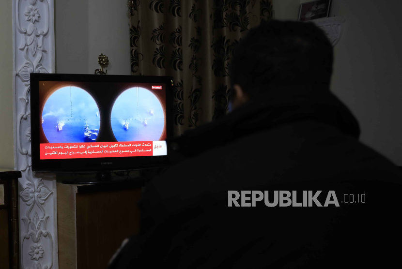 Seorang warga menyaksikan berita di TV Houthi setelah kapal Inggris diserang di Laut Merah, Sanaa, Senin (19/2/2024)
