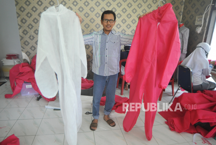 Pemilik UMKM Emi Arlin, Arlin Teguh menunjukan alat pelindung diri (APD) yang dibuat di Padang, Sumatera Barat, Kamis (26/3/2020). UMKM Emi Arlin memproduksi sedikitnya 300 lembar pakaian hazmat tersebut untuk memenuhi permintaan APD di Dinas Kesehatan Kota Padang, terkait mewabahnya COVID-19 di Indonesia