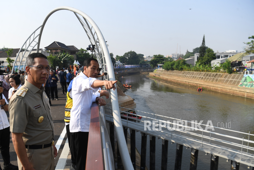 Presiden Joko Widodo (kanan) didampingi Pj Gubernur DKI Jakarta Heru Budi Hartono (kiri) melihat aliran sungai usai meresmikan sodetan Kali CIliwung di Jakarta, Senin (31/7/2023).