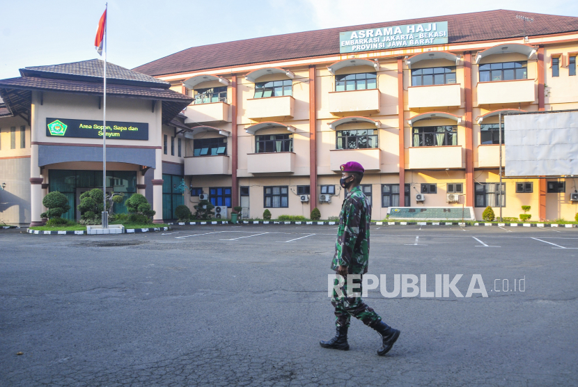 Anggota TNI berjaga di gerbang pintu masuk Asrama Haji Bekasi, Jawa Barat. Asrama Haji Kota Bekasi dipersiapkan menjadi rumah sakit darurat untuk isolasi Covid-19 Provinsi Jawa Barat.