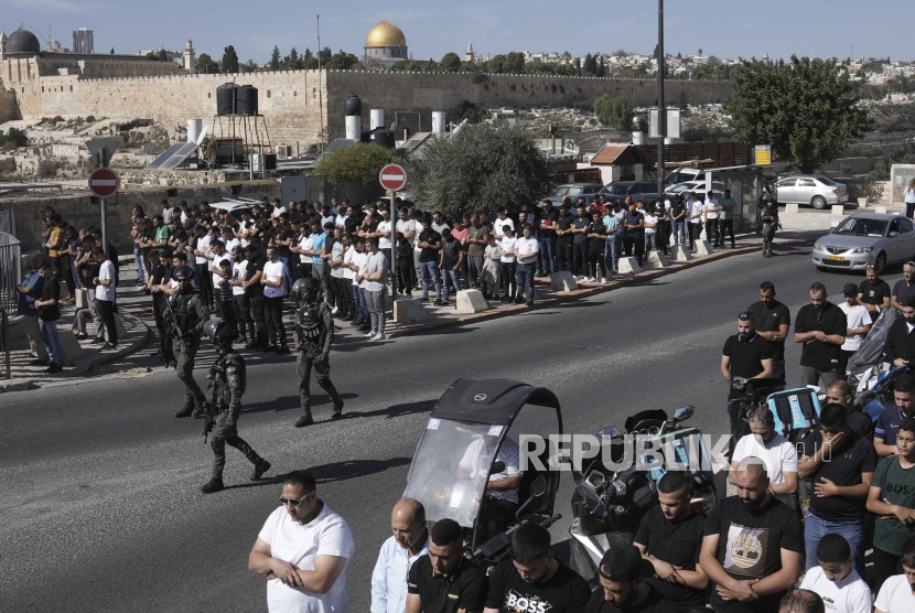 Jamaah Muslim Palestina yang dilarang memasuki Masjid Al-Aqsa melaksanakan sholat Jumat di pinggir jalan Kota Tua Yerusalem dengan pengawasan pasukan zionis Israel, Jumat (10/11/2023).