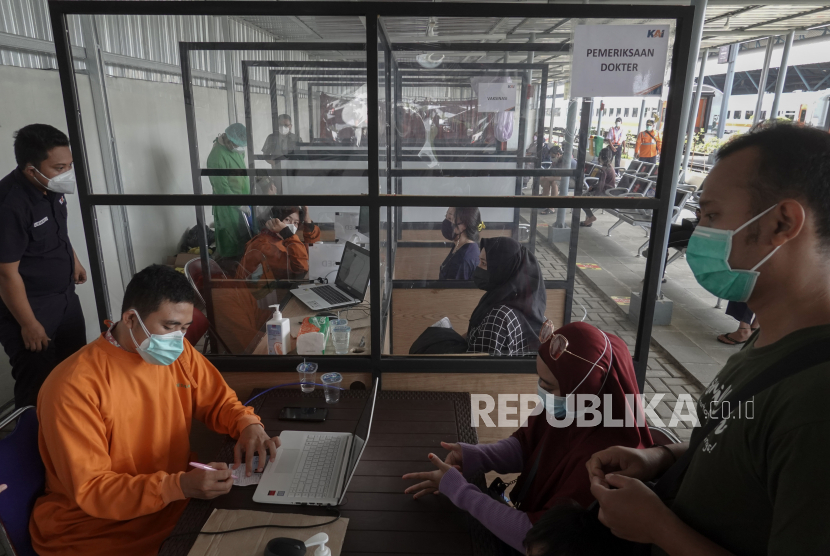 Petugas melakukan pemeriksaan kesehatan kepada calon penumpang kereta api yang akan melakukan vaksinasi COVID-19, di Stasiun Purwokerto, Banyumas, Jateng. KAI mencatat arus balik melalui Stasiun Purwokerto-Kutoarjo masih tinggi.