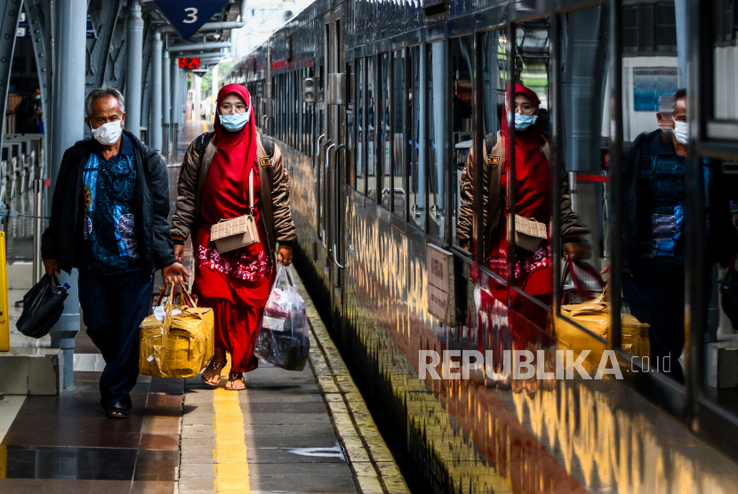 Penumpang yang ingin pulang kampung bersiap menaiki kereta di Stasiun Pasar Senen, Jakarta Pusat, Ahad (18/4/2021).