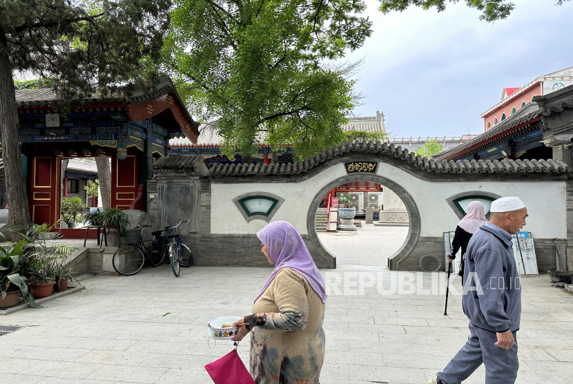 Warga suku minoritas Muslim Hui berjalan di halaman Masjid Madian, Distrik Haidian, Kota Beijing, China (ilustrasi). China mendorong 'pribumisasi' Islam dengan corak lokal  