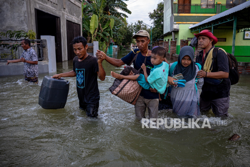 Warga meninggalkan rumah mereka yang terendam banjir akibat jebolnya tanggul Sungai Jratun-Wulan, di Desa Undaan Kidul, Kecamatan Karanganyar, Kabupaten Demak, Jawa Tengah, Kamis (8/2/2024). 