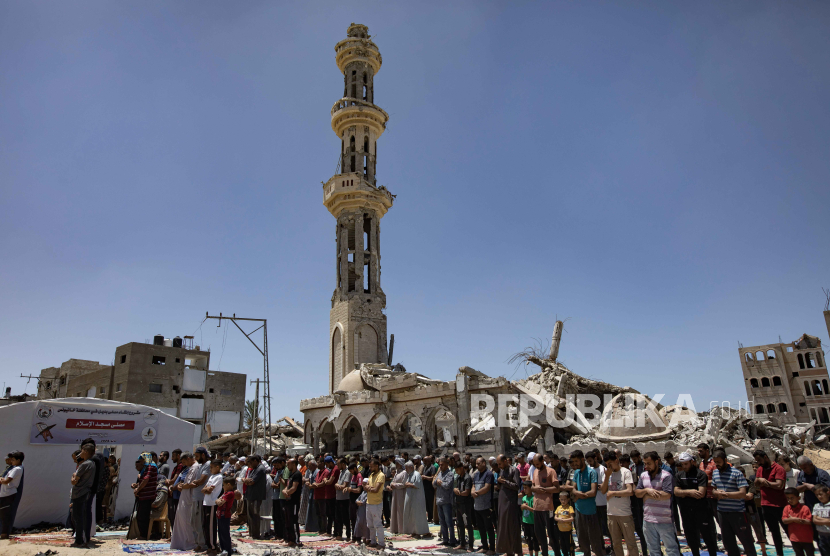 Pengungsi Palestina melaksanakan salat Jumat di samping reruntuhan Masjid Al-Islam, yang sebelumnya hancur akibat serangan udara Israel, di Khan Yunis, Jalur Gaza selatan, (24/5/2024).