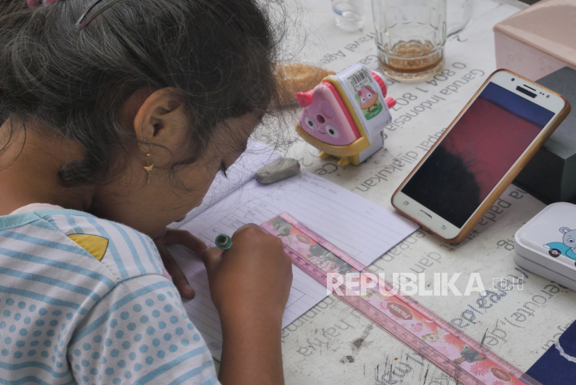 Quinina siswi kelas dua SDN 2 Sorogenen belajar di warung ibunya di kawasan Purwomartani, Sleman, Yogyakarta, Rabu (19/8). niversitas Gadjah Mada (UGM) menerjunkan 78 mahasiswa KKN PPM untuk membantu pembelajaran daring selama pandemi. Ilustrasi.