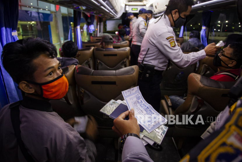 Petugas Dishub melakukan pendataan terhadap penumpang bus yang terjaring razia di Terminal Terpadu Pulo Gebang, Jakarta Timur, Jumat (22/5/2020). Bus tujuan Solo yang mengangkut tujuh orang tersebut diamankan karena memberangkatkan penumpang bukan dari Terminal Terpadu Pulo Gebang