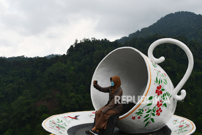 Pengunjung berswafoto di objek wisata Watu Rumpuk Desa Mendak, Dagangan, Kabupaten Madiun, Jawa Timur, Ahad (21/11/2021). Sejumlah pengunjung mulai mendatangi objek wisata yang berada di lereng Gunung Wilis tersebut, sejak dibuka kembali setelah sebelumnya  ditutup karena masa pandemi COVID-19 ditutup. 