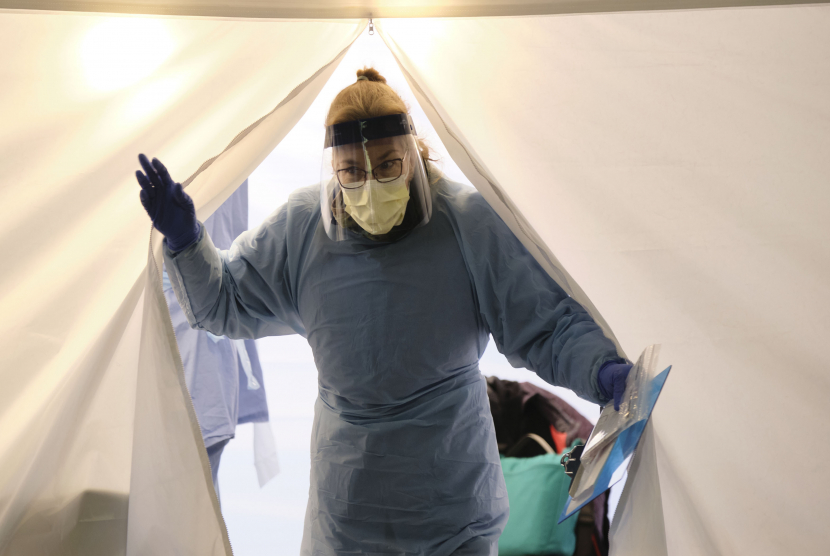 Seorang perawat muncul dari tenda dengan kit untuk menguji Covid-19 di sebuah drive melalui stasiun pengujian untuk karyawan Pusat Medis Universitas Washington di Seattle, Washington, AS.