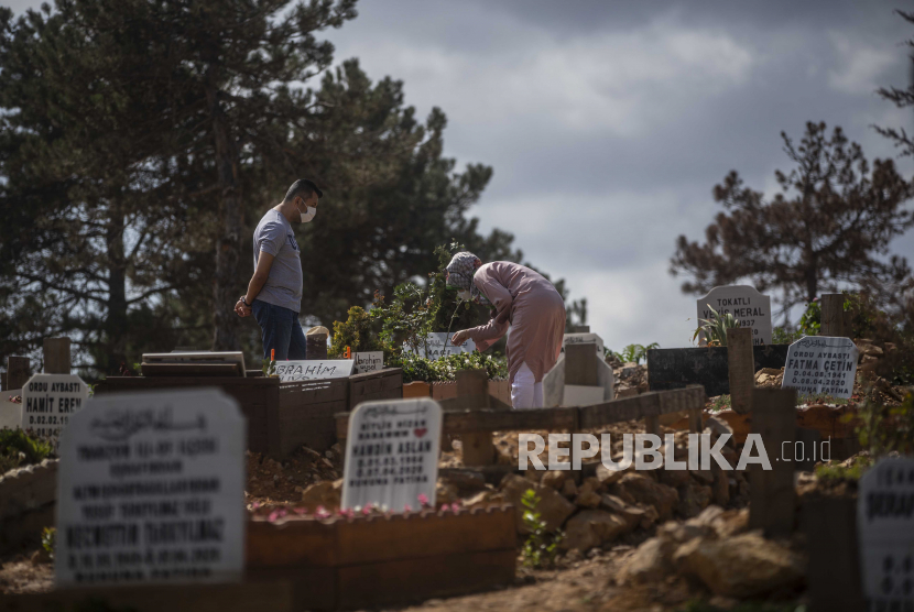  Kerabat korban Covid-19 membersihkan kuburannya di pemakaman Baklaci di Istanbul, Turki, 18 September 2020. 