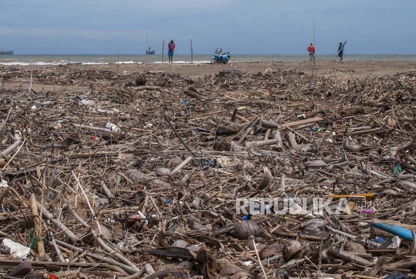Warga berada di sekitar tumpukan di Pantai Bayah, Lebak, Banten, Ahad (29/5/2022). Gelombang tinggi yang terjadi beberapa hari terakhir di daerah tersebut mengakibatkan sampah dari limbah rumah tangga serta plastik terbawa oleh arus ombak dan menumpuk di pantai itu. 