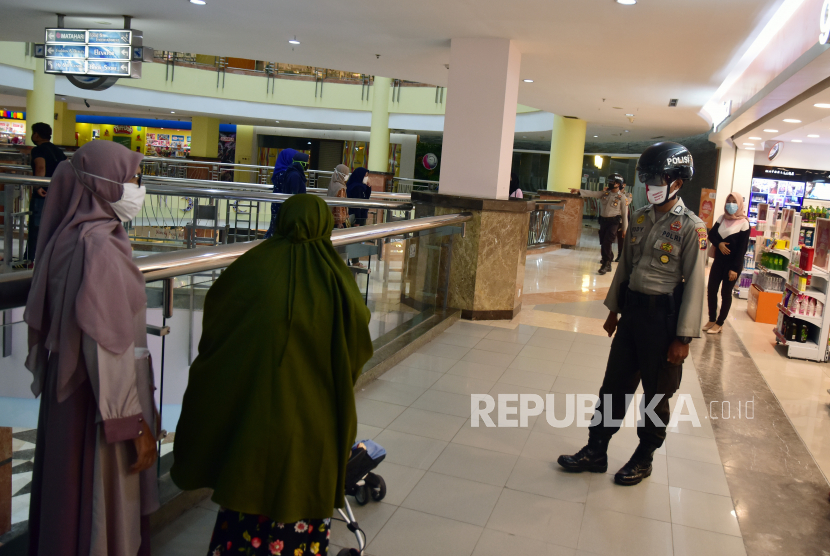 Sejumlah personel Polresta Pekanbaru (kanan) mengenakan helm pendeteksi suhu badan saat patroli di pusat perbelanjaan Mal SKA di Kota Pekanbaru, Riau, Senin (1/6/2020). Polri mengunakan teknologi helm pintar pendeteksi suhu tubuh untuk mendukung rencana penerapan kenormalan baru (new normal) COVID-19