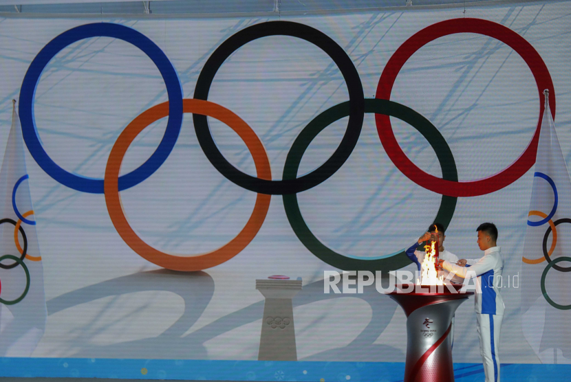 Peserta memindahkan nyala api Olimpiade dari kuali pada upacara penyambutan nyala api Olimpiade Musim Dingin Beijing 2022 di Beijing, Tiongkok, 20 Oktober 2021. 